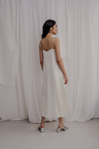 Braut die ein Brautkleid aus Viskose trägt. das Brautkleid fällt schlicht und hat 2 mit Perlen bestickte Träger