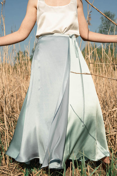 Das Model trägt einen mittellangen Wickelrock aus Seide