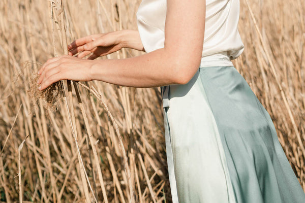 Das Model trägt einen mittellangen Wickelrock aus Seide