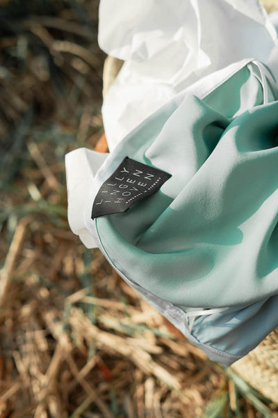 Das Model trägt einen mittellangen Wickelrock aus Seide