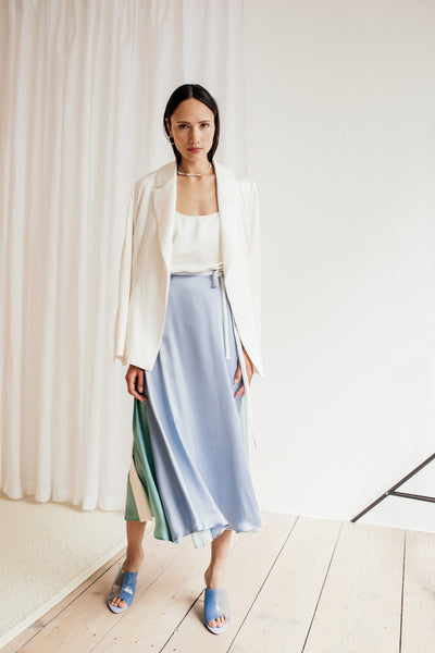 Das Model trägt einen mittellangen Wickelrock aus Seide